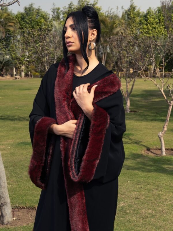 Black crepe kaftan with burgundy fur details on the sleeves and front for a bold and luxurious touch.