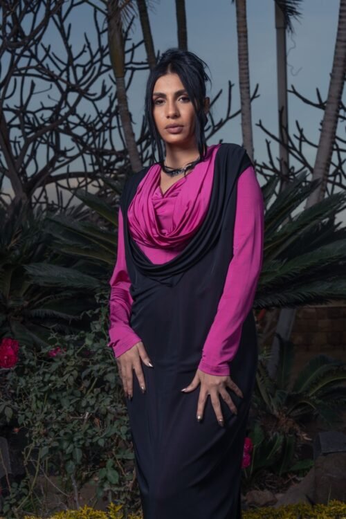 Draped collar dress paired with a long vest for a chic and modern style