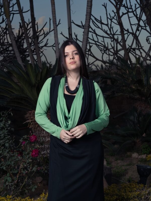 Draped collar dress paired with a long vest for a chic and modern style